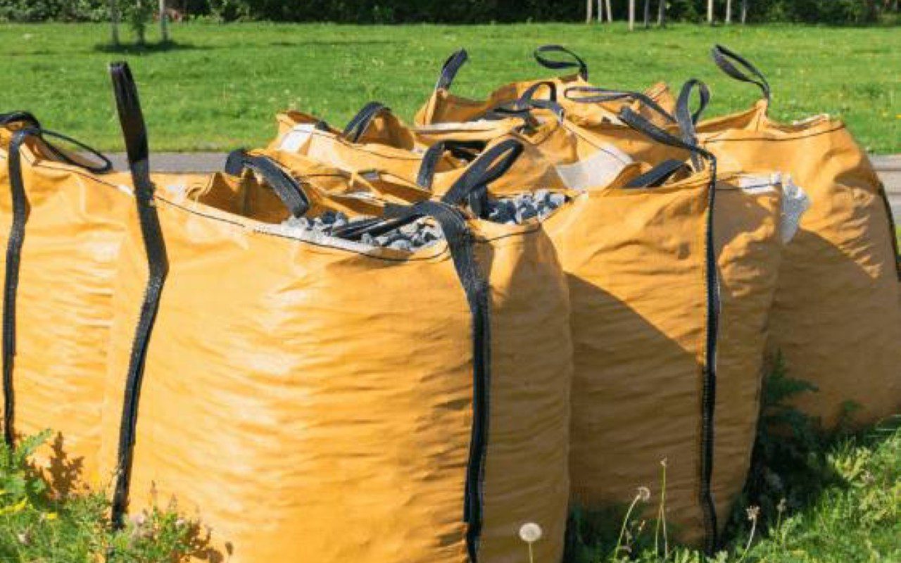 Large yellow bags filled with rocks outdoors.