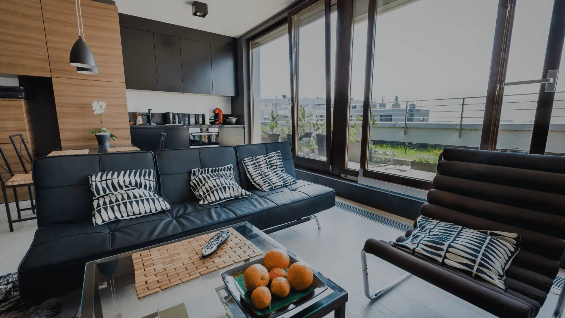 Modern living room with black sofa and windows.